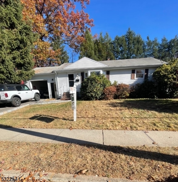 single story home featuring a front yard and a garage