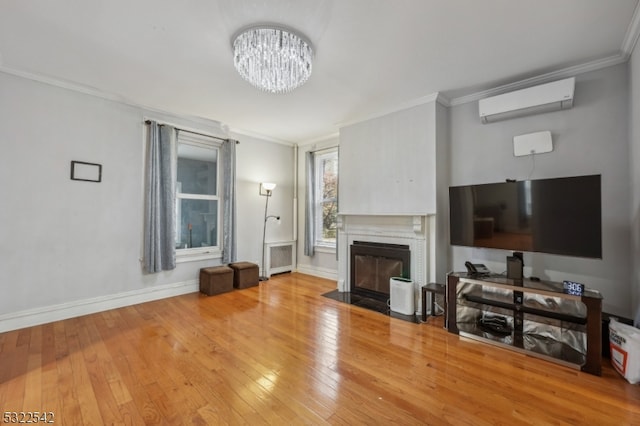 living room featuring hardwood / wood-style flooring, a wall mounted air conditioner, an inviting chandelier, radiator heating unit, and crown molding