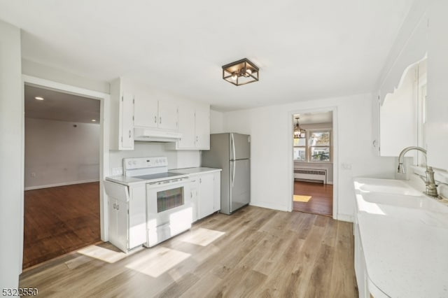 kitchen with radiator, white cabinets, electric range, stainless steel refrigerator, and light hardwood / wood-style flooring