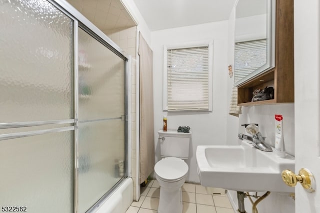 full bathroom with sink, shower / bath combination with glass door, toilet, and tile patterned flooring