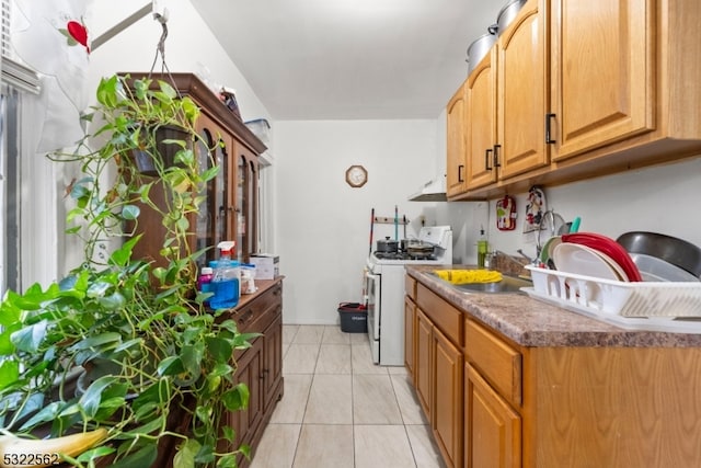 kitchen with sink, white gas stove, and light tile patterned floors