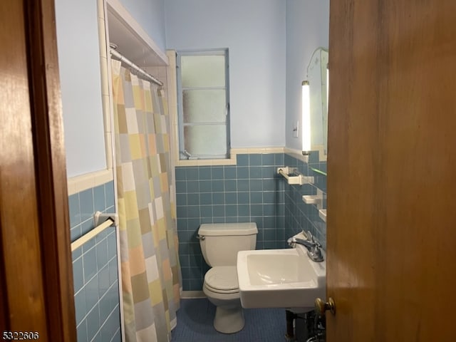 bathroom featuring tile walls, sink, and toilet