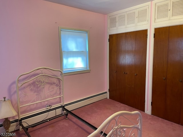 bedroom with a baseboard heating unit and carpet