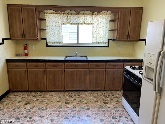 kitchen featuring decorative backsplash, sink, and white appliances