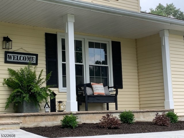 view of exterior entry featuring covered porch