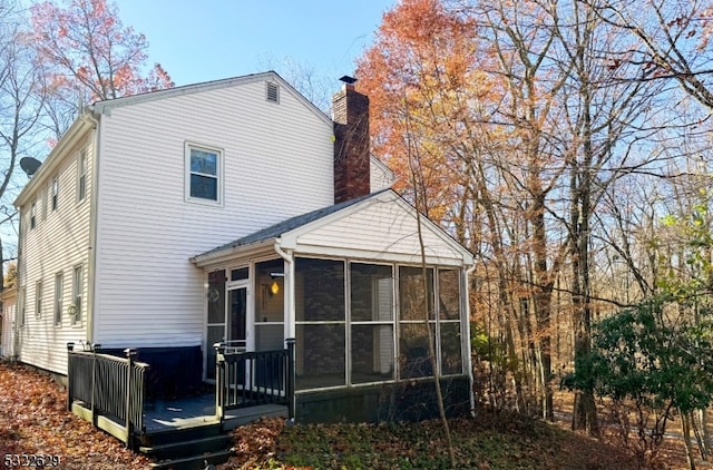 back of house featuring a sunroom and a deck