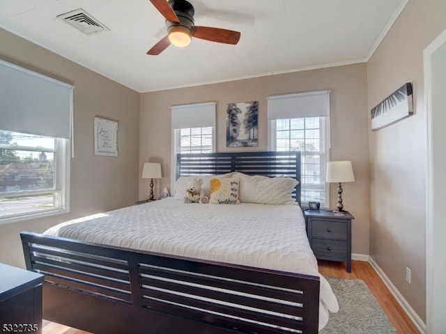 bedroom with ceiling fan, light hardwood / wood-style flooring, and crown molding