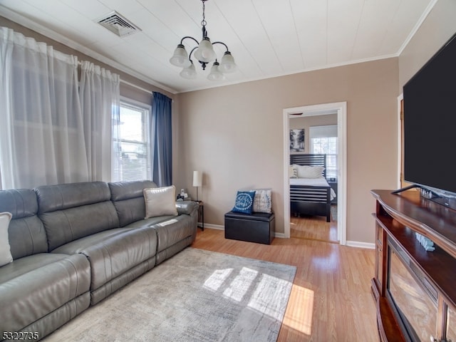 living room featuring ornamental molding, light hardwood / wood-style flooring, and a notable chandelier