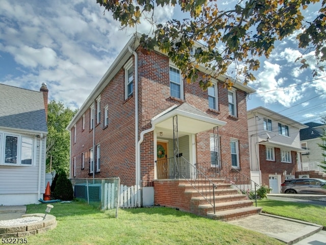 townhome / multi-family property featuring a front lawn