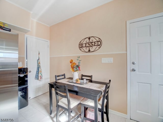 dining area featuring light tile patterned flooring and crown molding