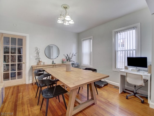 dining area with hardwood / wood-style flooring and a chandelier