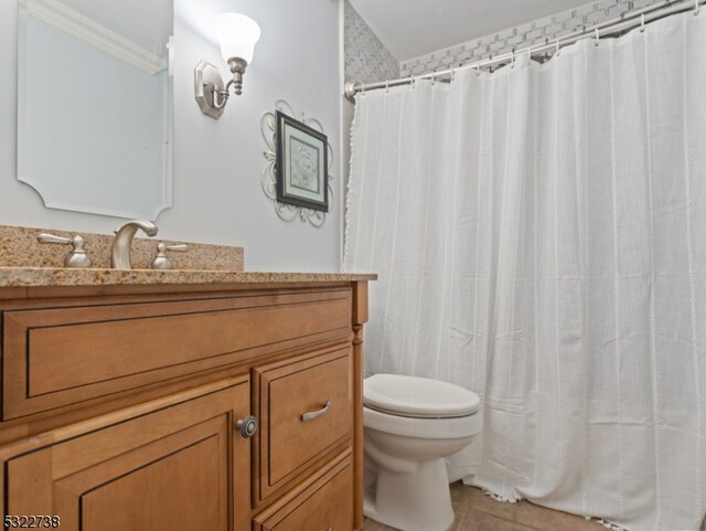 bathroom featuring toilet, vanity, tile patterned floors, and curtained shower