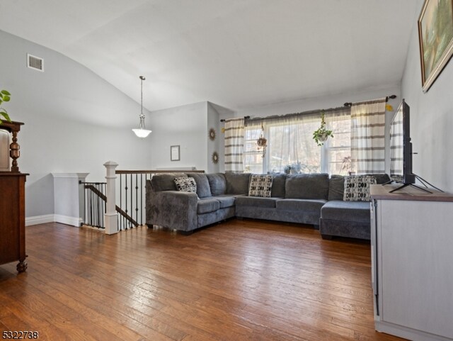 living room featuring dark wood-type flooring and lofted ceiling