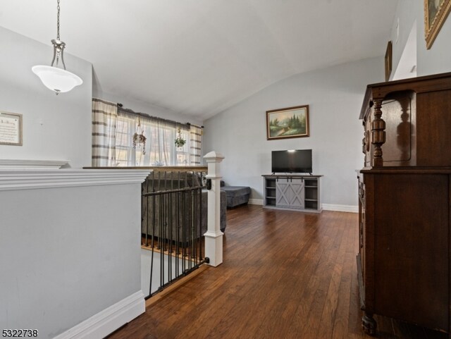 hallway with dark wood-type flooring and lofted ceiling