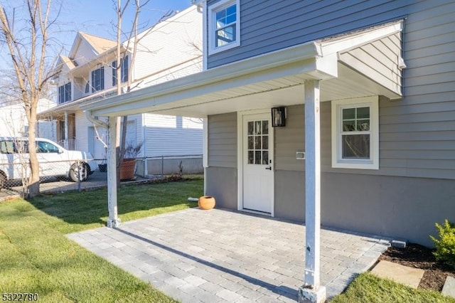 property entrance featuring a yard and a patio