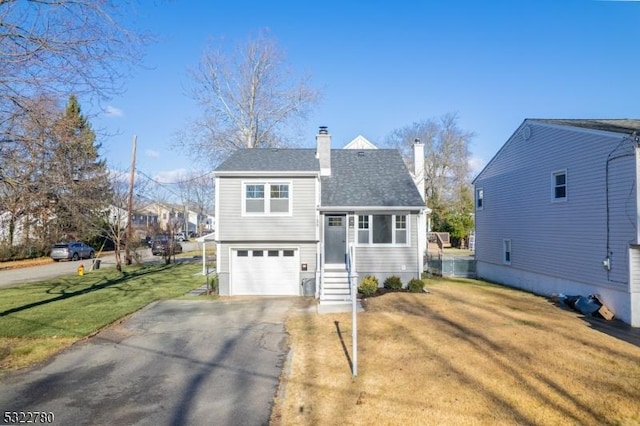 view of property with a garage and a front lawn