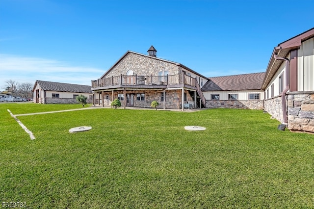 back of property with a wooden deck and a yard