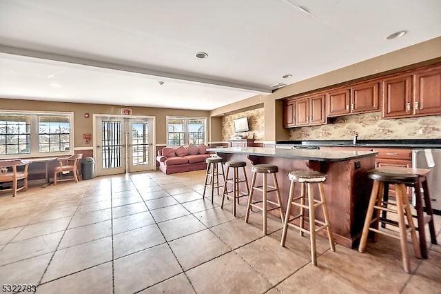 kitchen featuring a kitchen bar, a healthy amount of sunlight, decorative backsplash, and a center island