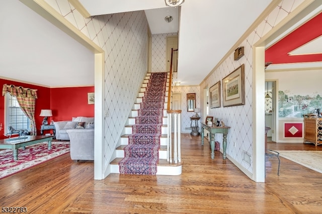 foyer with hardwood / wood-style flooring and crown molding