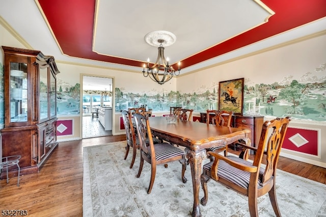 dining area featuring crown molding, dark hardwood / wood-style flooring, a notable chandelier, and a raised ceiling