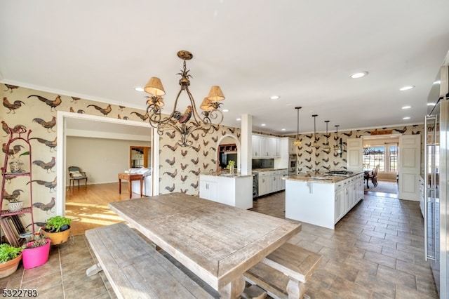 dining space with wood-type flooring, a notable chandelier, and ornamental molding