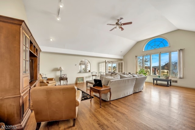 living room with ceiling fan, track lighting, light wood-type flooring, and vaulted ceiling