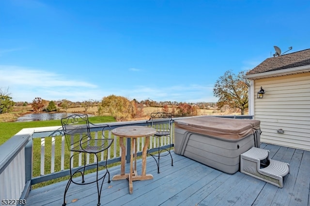 wooden terrace featuring a hot tub and a water view