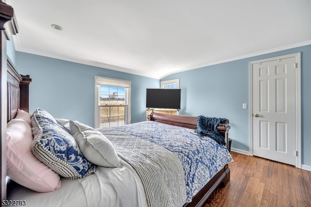 bedroom with hardwood / wood-style floors, lofted ceiling, and crown molding