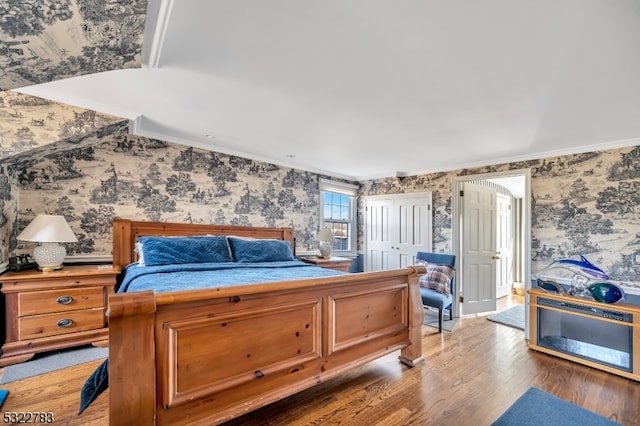 bedroom with hardwood / wood-style flooring, crown molding, and a closet