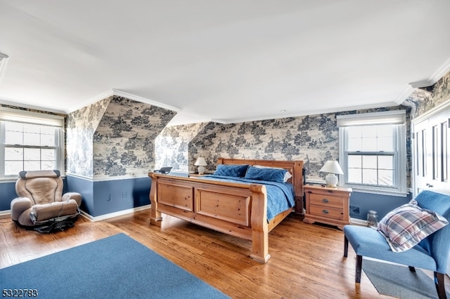 bedroom featuring hardwood / wood-style flooring, multiple windows, and crown molding