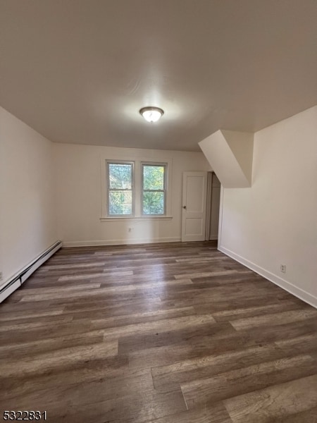 additional living space with dark hardwood / wood-style flooring