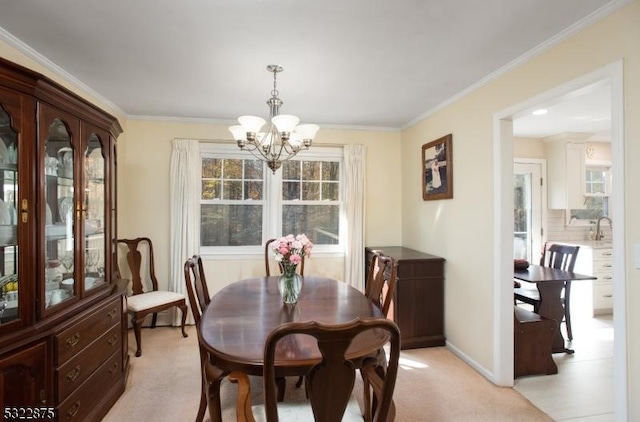 dining room with light carpet, an inviting chandelier, baseboards, and crown molding