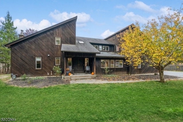 rear view of property featuring a yard