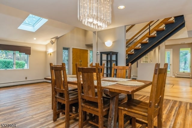 dining space with wood-type flooring, plenty of natural light, and baseboard heating