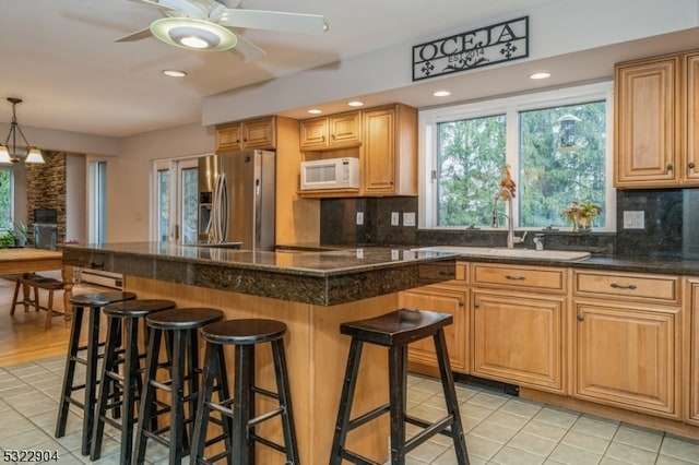 kitchen featuring decorative backsplash, stainless steel fridge, and a breakfast bar