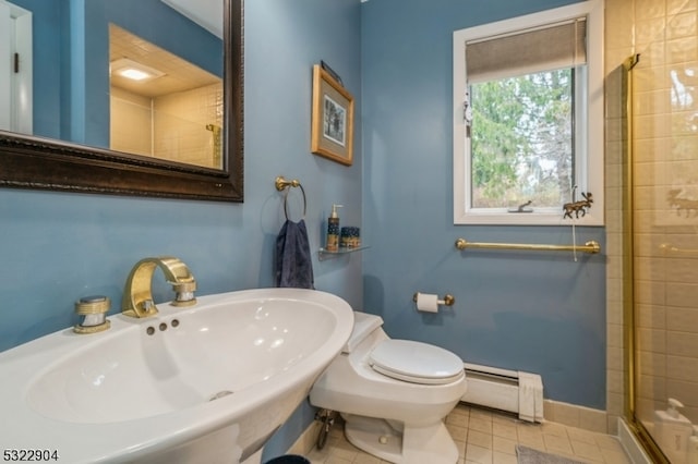 bathroom with walk in shower, toilet, sink, and a baseboard radiator