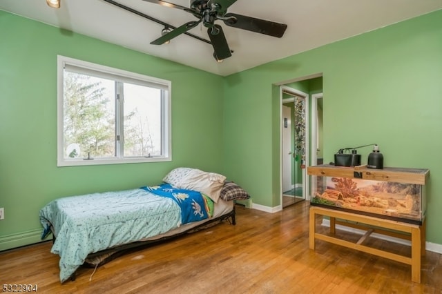 bedroom with hardwood / wood-style floors and ceiling fan