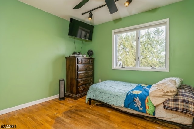 bedroom featuring hardwood / wood-style floors, ceiling fan, and rail lighting