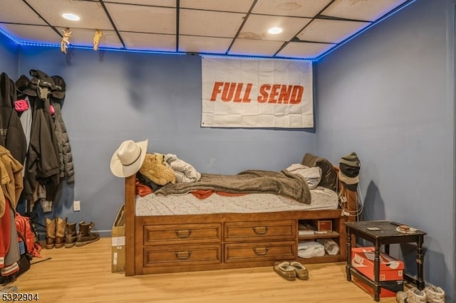 bedroom featuring light wood-type flooring and a paneled ceiling