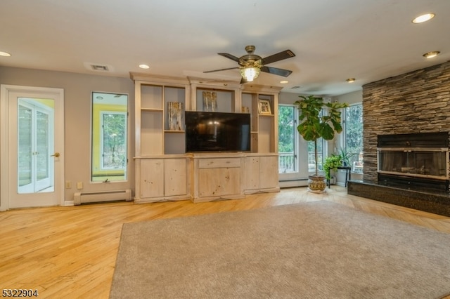 unfurnished living room featuring a fireplace, a baseboard radiator, ceiling fan, and light hardwood / wood-style flooring