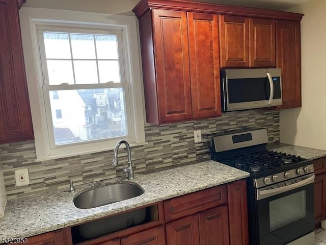 kitchen featuring decorative backsplash, stainless steel appliances, and sink