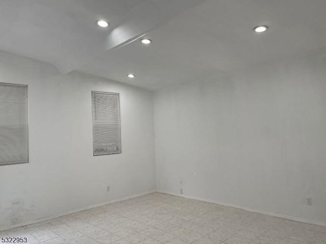 unfurnished room with vaulted ceiling