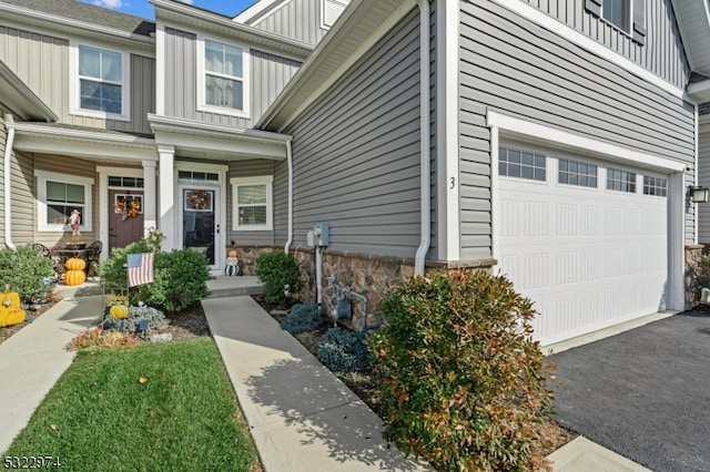 doorway to property featuring a garage and covered porch