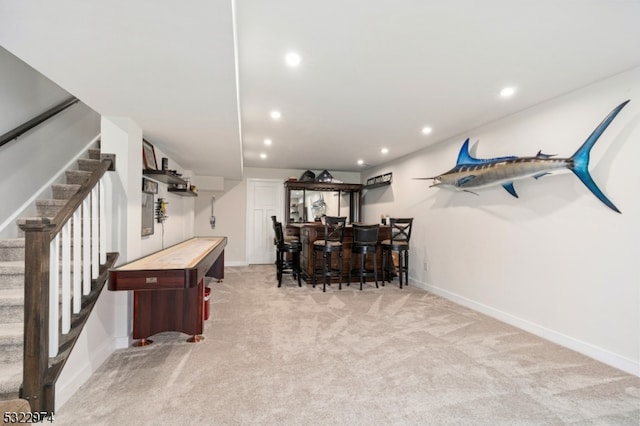 game room featuring bar area and light carpet