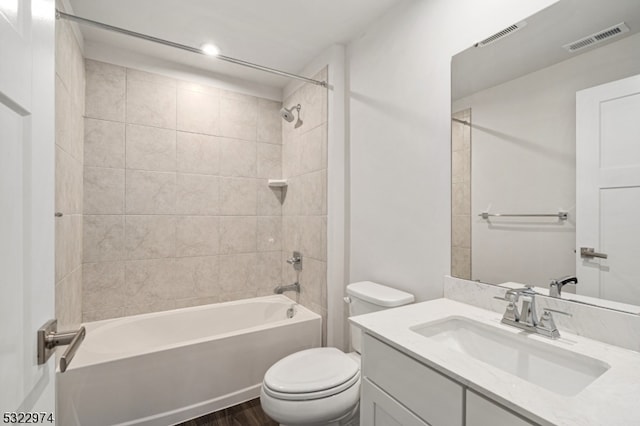 full bathroom featuring toilet, tiled shower / bath combo, vanity, and hardwood / wood-style flooring