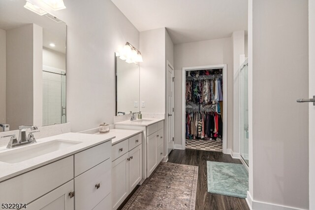 bathroom featuring walk in shower, vanity, and hardwood / wood-style flooring