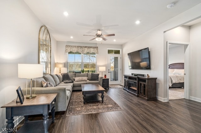 living room featuring dark hardwood / wood-style flooring and ceiling fan