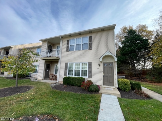 view of front of home featuring a front lawn and a balcony