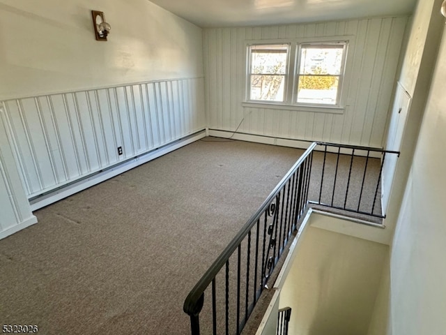 carpeted empty room with a baseboard radiator