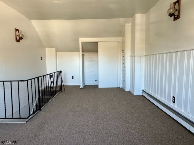 interior space with vaulted ceiling, carpet flooring, and a baseboard radiator